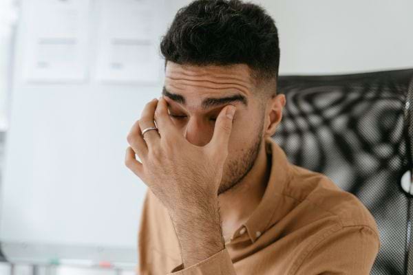 Un homme se frotte les yeux, risquant d’introduire des virus.