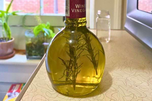 Bouteille ronde avec de l'huile d'olive infusée au romarin.