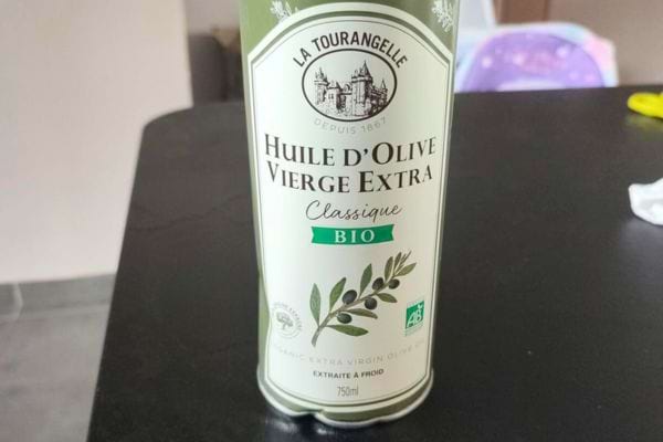 Bouteille d'huile d'olive bio La Tourangelle posée sur une table.