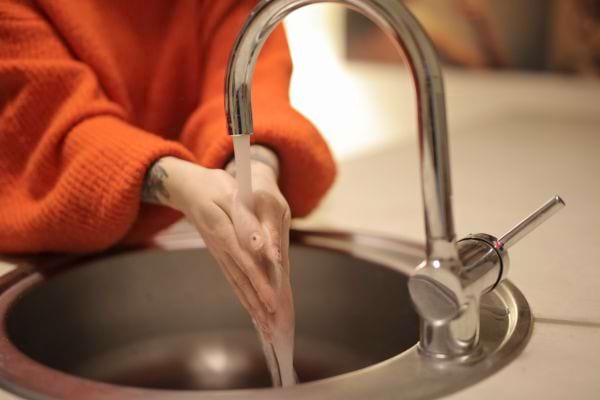 Une personne se lave les mains sous l’eau pour éliminer les microbes.