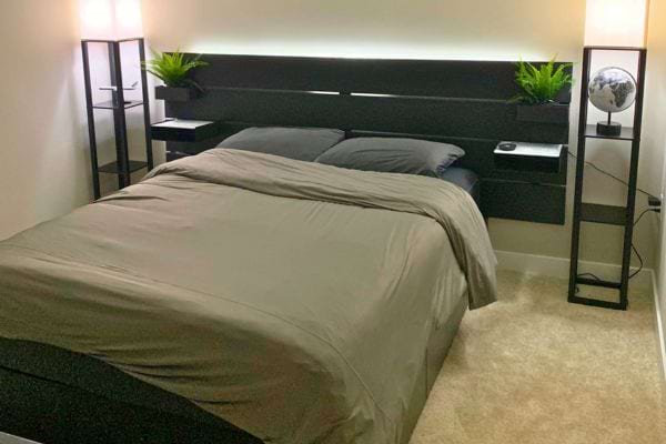 Lit bien fait dans une chambre minimaliste.