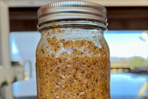 Moutarde à l’ancienne avec grains dans un bocal en verre.