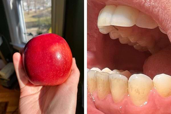 Une main tenant fermement une pomme rouge sous la lumière du soleil.