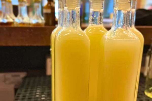 Verre de jus de citron posé près d'un citronnier avec des citrons.