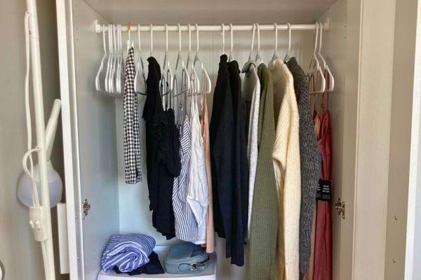 Vêtements bien rangés dans un placard.