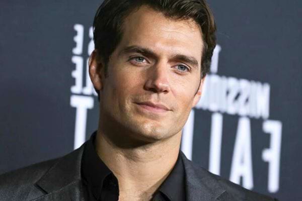 Henry Cavill en costume, expression confiante.