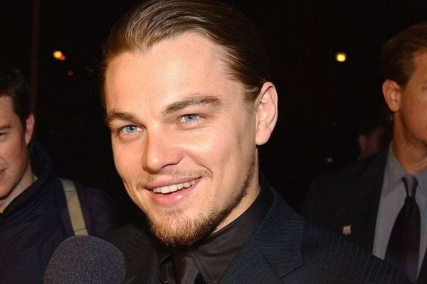 Leonardo DiCaprio en smoking noir, souriant.
