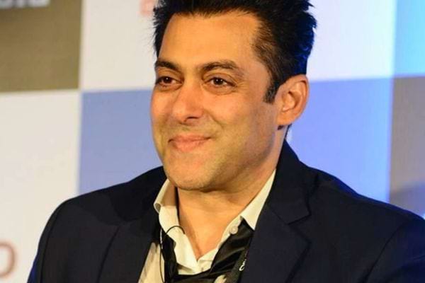 Salman Khan souriant en costume sombre.