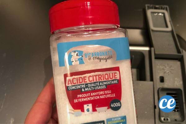 Boîte d’acide citrique montrée en gros plan devant le lave-vaisselle.