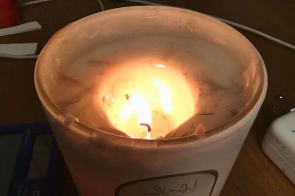 Bougie avec un creux au milieu et une flamme brûlant profondément.