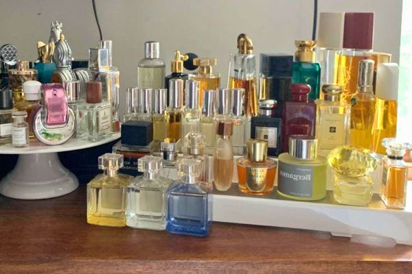 Collection variée de parfums sur une table en bois.