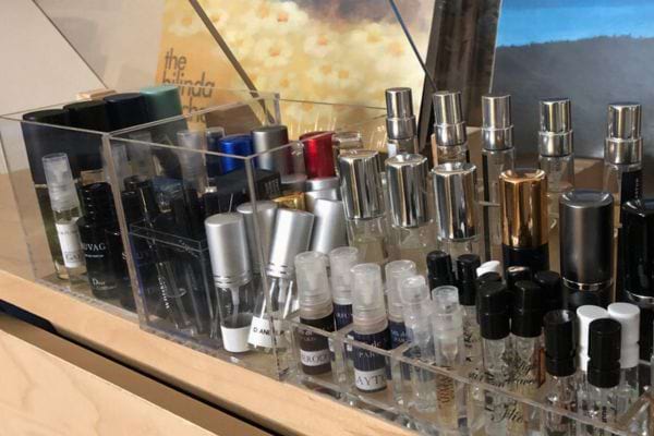 Échantillons de parfums rangés dans une boîte transparente.