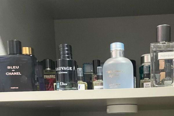 Parfums Dior et Chanel sur une étagère.