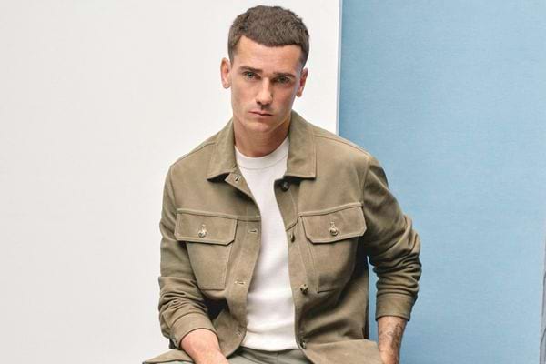 Antoine Griezmann en veste beige, posé.