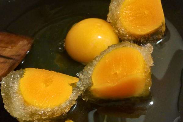 Des jaunes d'œufs congelés coupés en morceaux dans un bol.