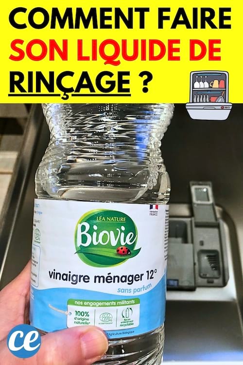 Une bouteille de vinaigre blanc devant un lave-vaisselle comme liquide de rinçage