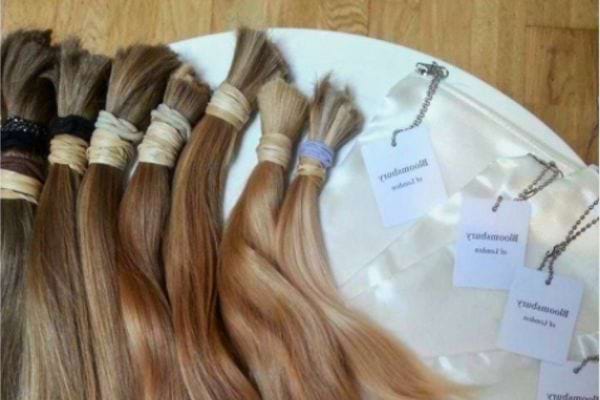 Mèches de cheveux blonds alignées avec étiquettes de vente.