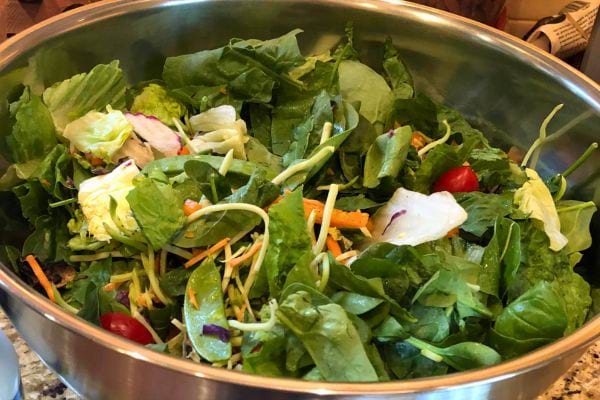 Mélange de feuilles de salade avec tomates et légumes.