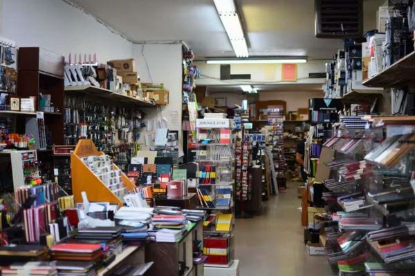 Magasin de papeterie avec des rayons remplis de fournitures.