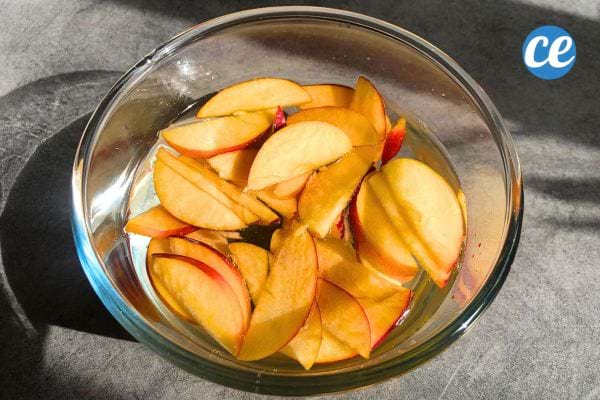 Tranches de pommes dans un bol d'eau.