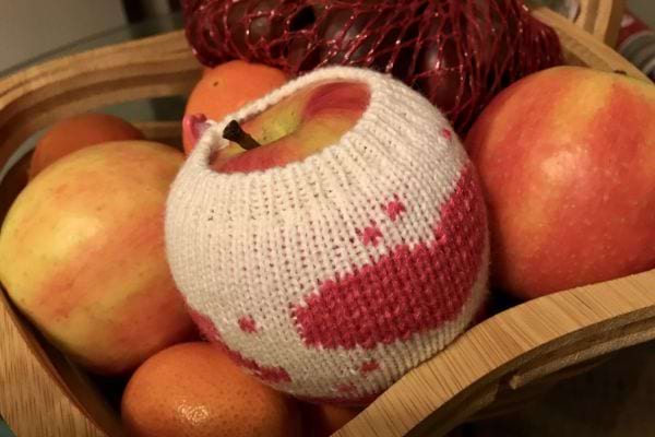 Pomme enveloppée dans un tricot dans une corbeille de fruits.