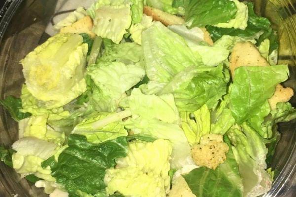 Salade romaine avec croutons dans un contenant plastique.