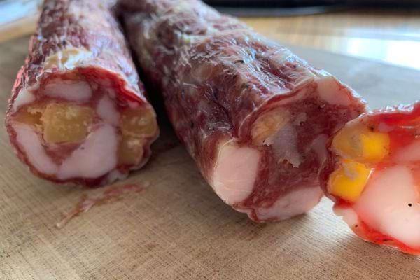 Un saucisson coup&eacute; montrant des morceaux gras et de viande.