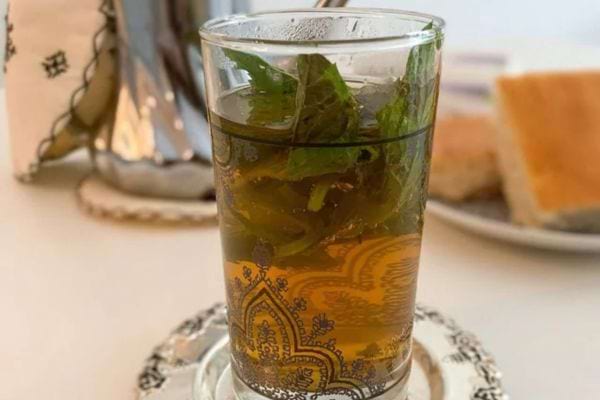 Thé à la menthe dans un verre décoré.