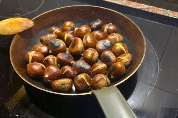 Châtaignes grillant dans une poêle.