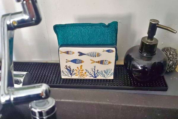 Éponge verte posée près d'un évier.