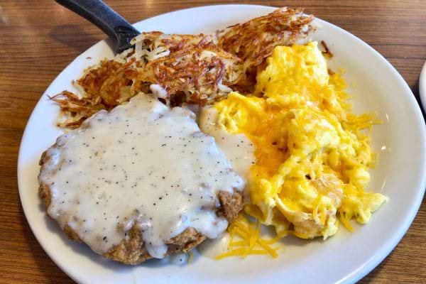 Petit déjeuner avec œufs, pommes de terre et sauce gravy.