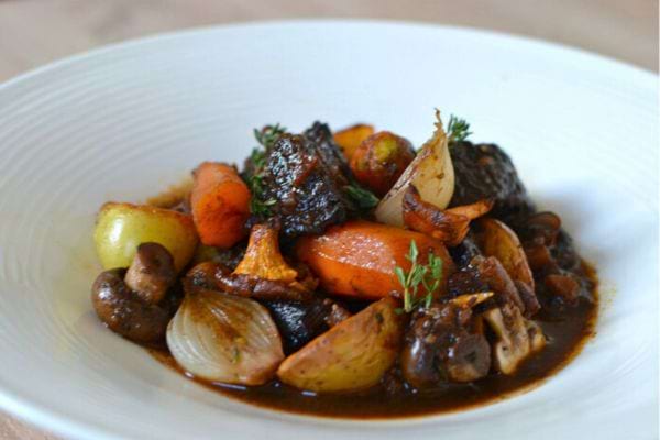 Assiette de bœuf aux légumes racines et sauce brune.