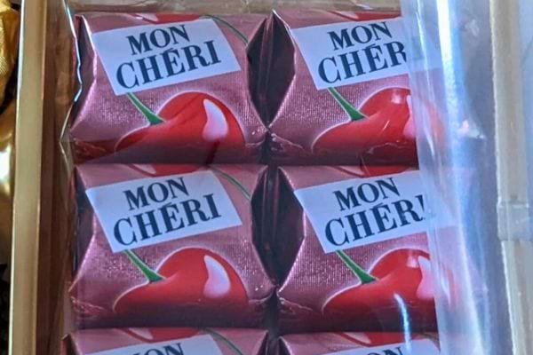Six chocolats Mon Chéri emballés dans une boîte en plastique transparente.