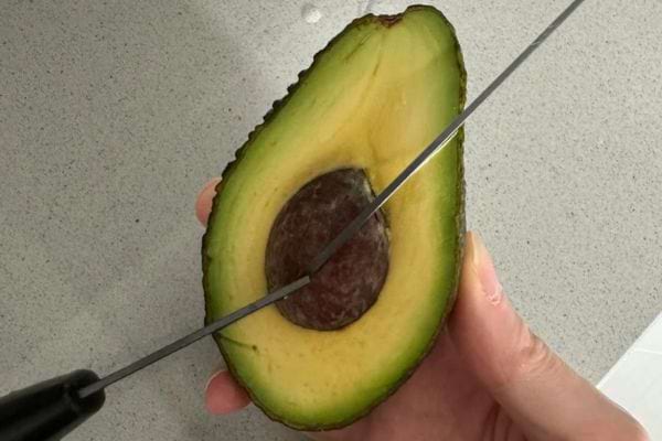 Avocat coupé avec couteau sur noyau.