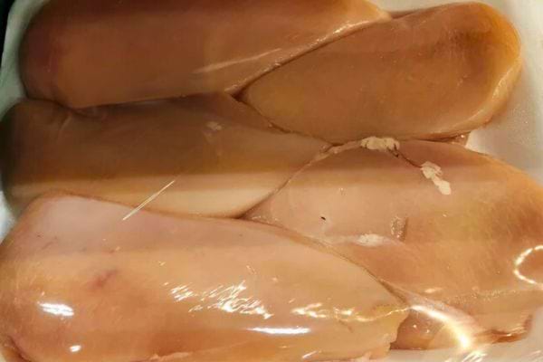 Filets de poulet frais emballés sous film plastique.