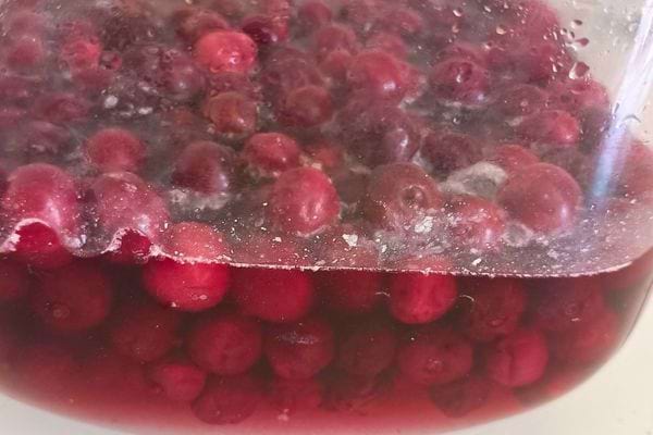 Des framboises mijotant dans une compote rouge.