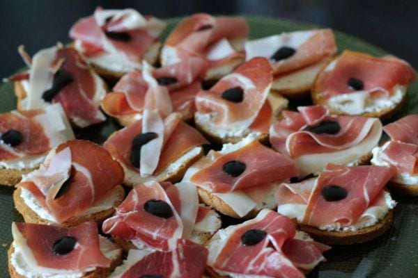 Toasts au jambon cru, crème et olives noires sur pain de mie.