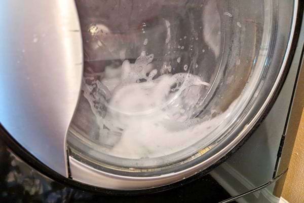 Vue intérieure d'une machine à laver en cycle de lavage.