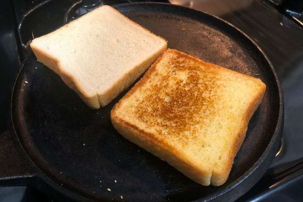 Pain grillé dans une poêle noire sur une cuisinière.
