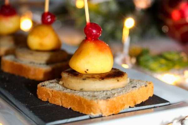 Canapé avec poire grillée et cerise sur pain noir.