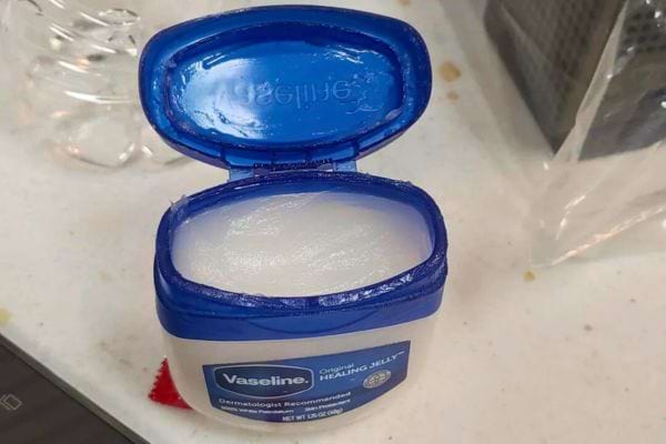 Pot de Vaseline ouvert sur un plan de travail sali.