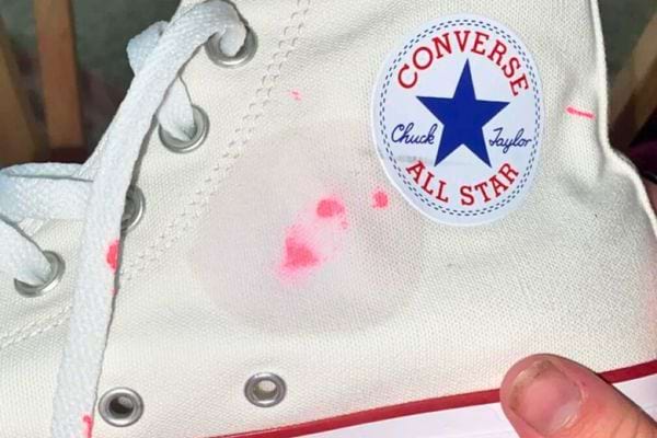 Tache rose sur une chaussure blanche Converse.