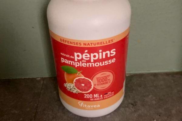 Bouteille de pépins de pamplemousse sur fond vert.