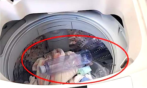 Une bouteille en plastique dans le tambour de la machine à laver