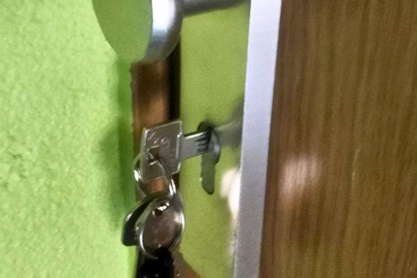 Clés dans la serrure d'une porte verte, vue rapprochée.