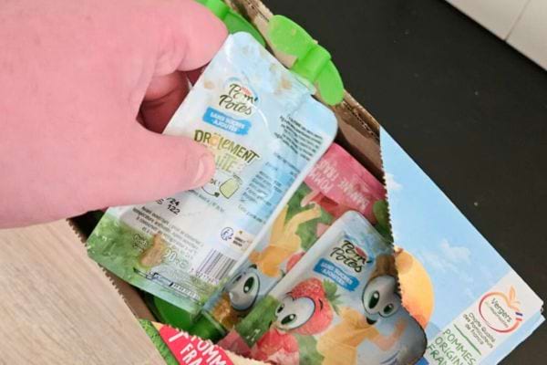 Main tenant un sachet de compote de pomme.