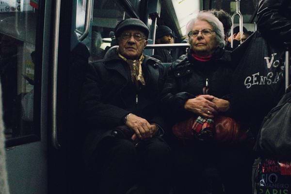 Un couple âgé assis dans un métro.