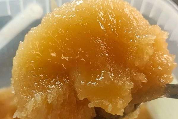 Gros plan sur du miel cristallisé sur une cuillère.