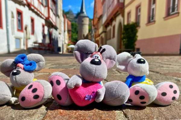 Trois petites souris Diddl posées sur un pavé.