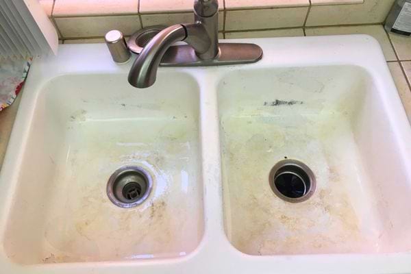 Évier avec diverses taches et résidus.